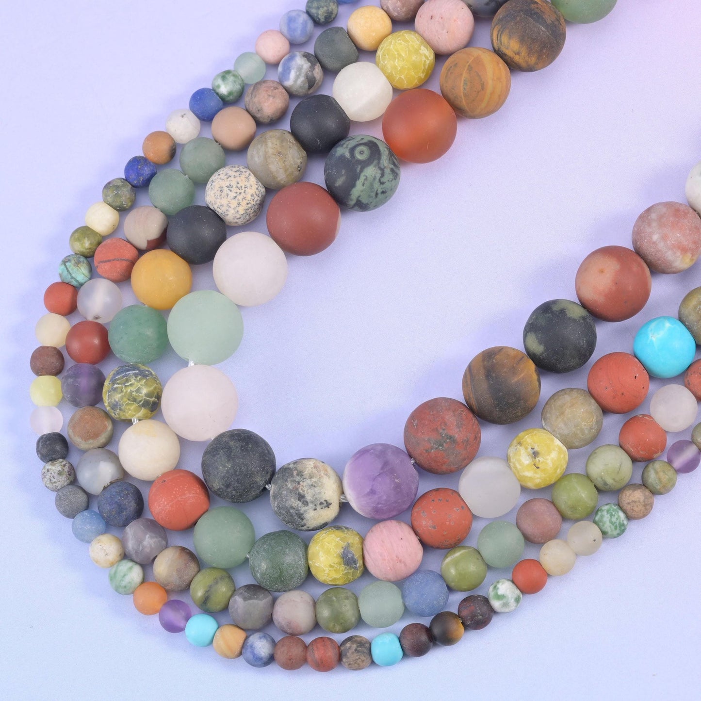 Matte gemstone rounds curving in a V, mixing larger and smaller beads