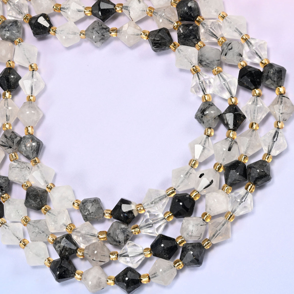 Black rutilated quartz bicone beads formed into a wide open ring, light passing through the clearer beads while the heavily included ones stay dark.