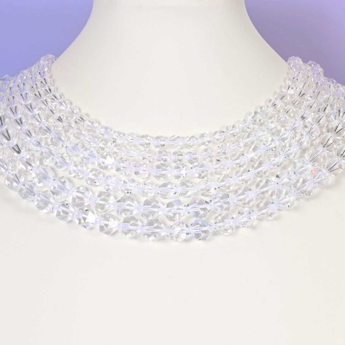 Clear Quartz diamond star cut beads looped over a white display stand, faceted 6mm to 10mm rounds