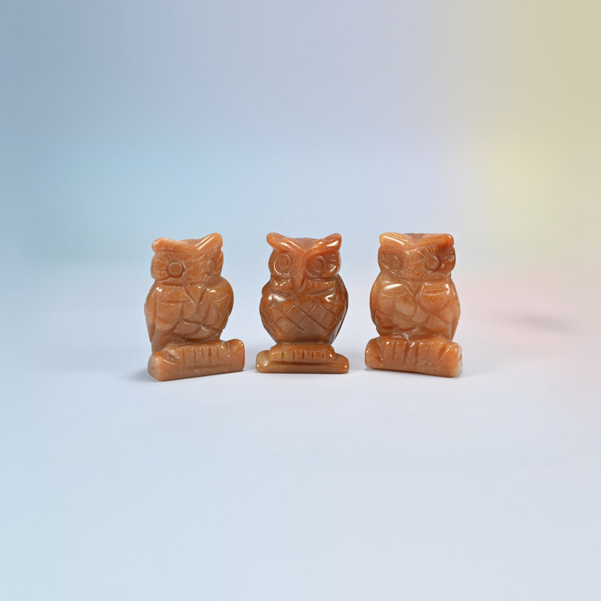 Owl crystal carving in red aventurine, orange-red natural stone with a soft shimmer