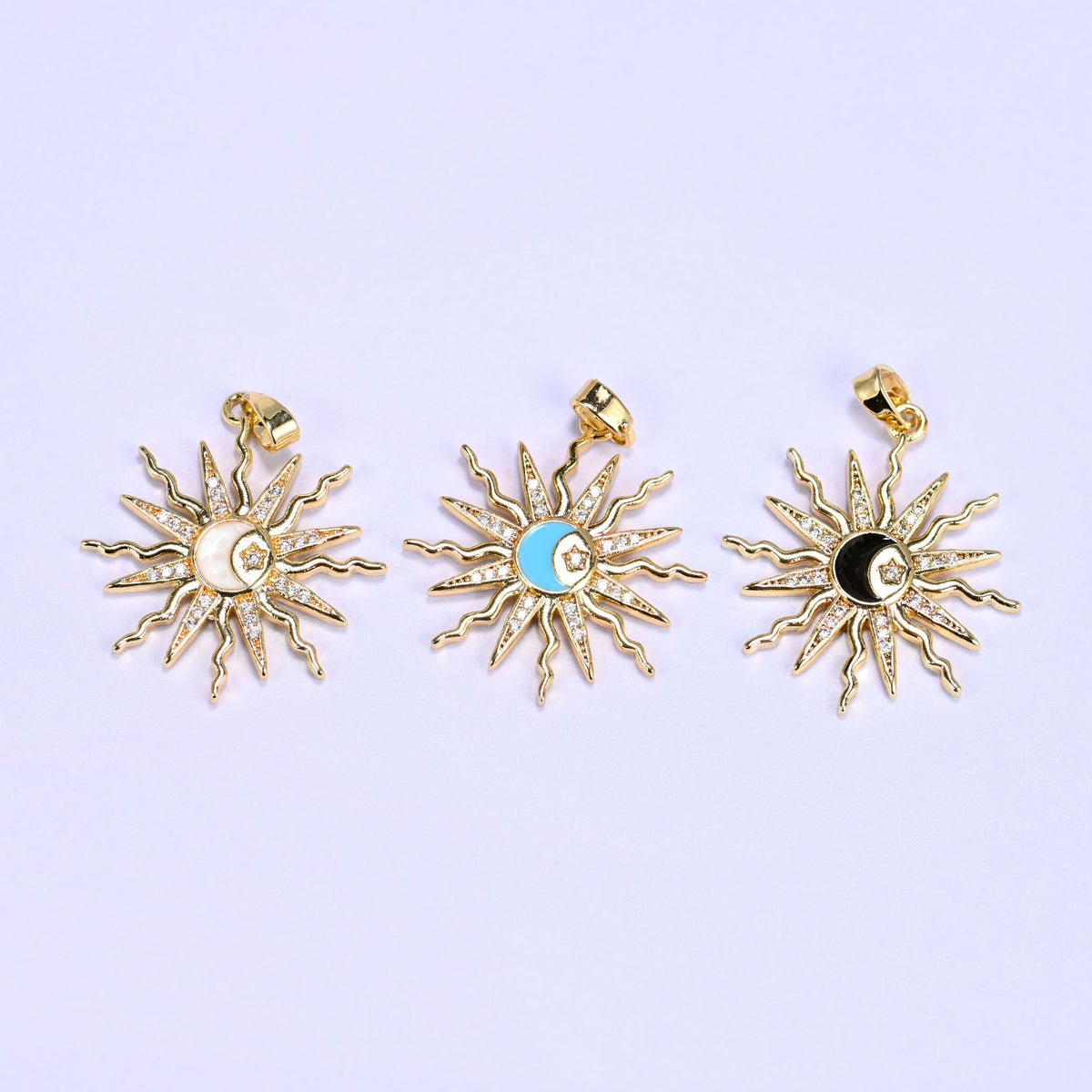 Three enamel moon sun zirconia charms lined up in white, blue and black, each gold sunburst set with clear zirconia rays.