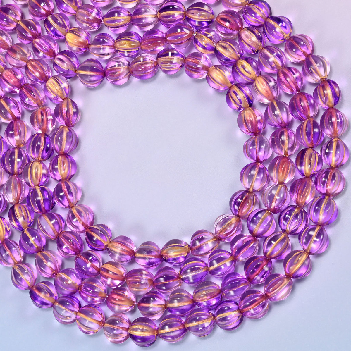 Purple gold pumpkin glass beads coiled into a wide open ring, gold ribs catching the light.