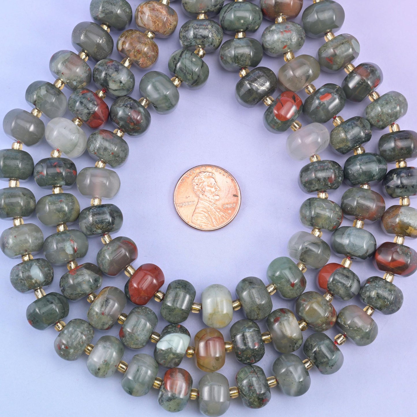 Pumpkin rondelles coiled around a penny, colour running from pale sage to dark rust