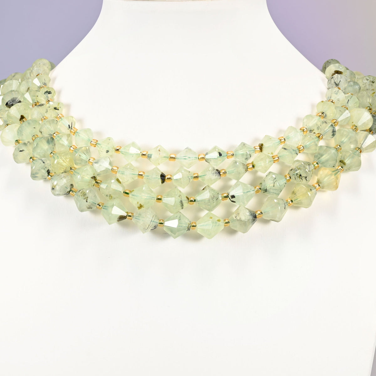 Strand of Green Prehnite faceted bicone beads, 8mm and 10mm, worn on a jewelry display bust, showing the necklace-length drape.