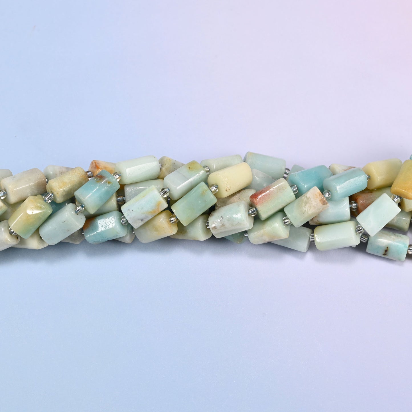 Close-up of Multi-Color Amazonite faceted tube beads showing the flat cut planes, polished surface and clear glass seed bead spacers