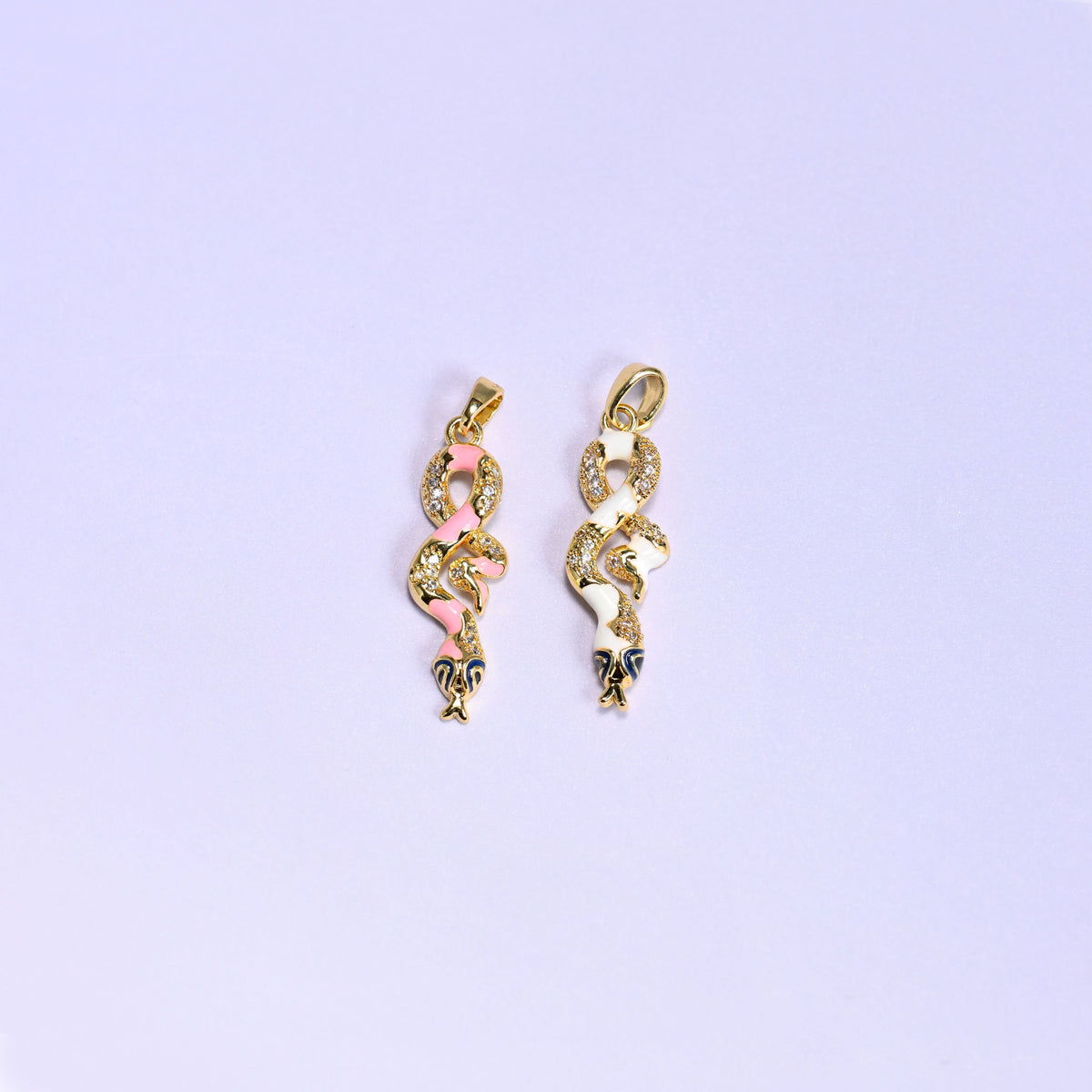 Enamel Snake Zirconia Charms colorway pair, the pink enamel snake next to the white enamel snake, both 18K gold plated with zirconia pave detail.