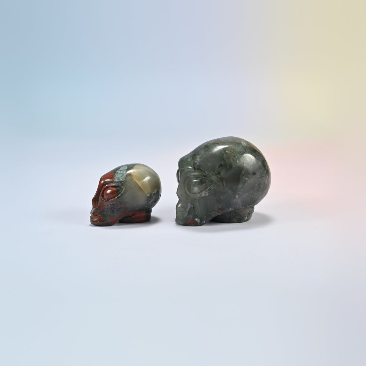 Two African bloodstone alien head crystal carvings, 1.5 inch and 2 inch, dark green and gray natural stone with red patches