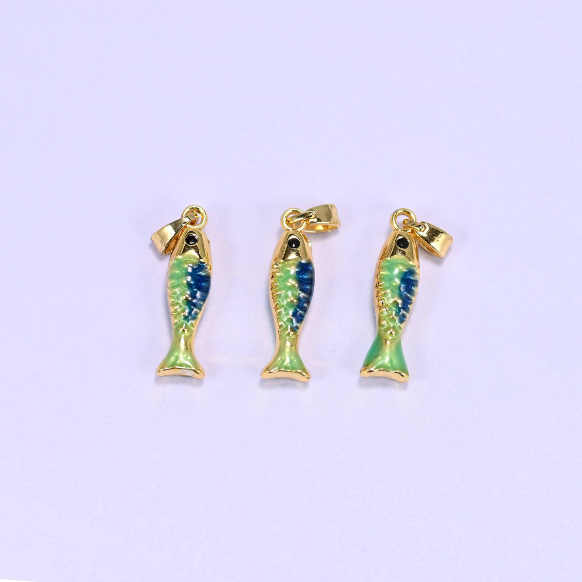 Fish charm in blue and green enamel with a glossy gold tail