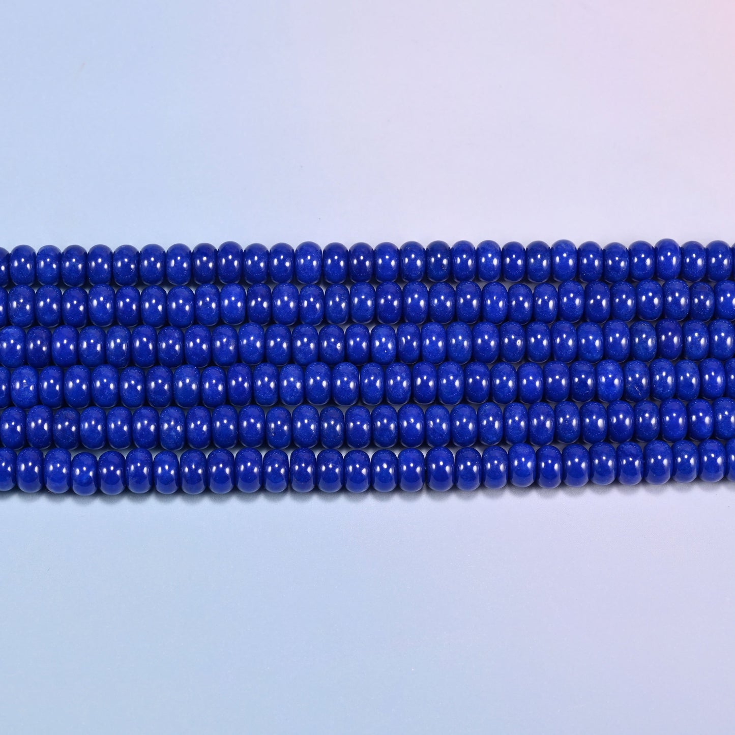 Dark Blue dyed jade gemstone rondelle beads in straight rows, showing the flat 5x8mm disc profile and centre drilling