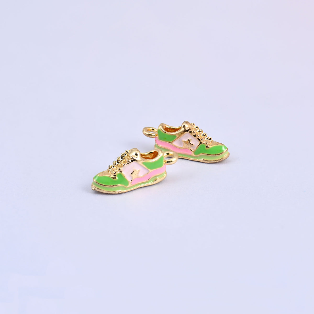 Two green sneaker charms with pink and light yellow panels.
