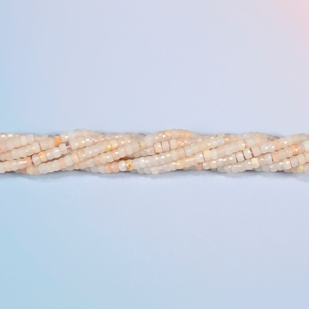 Strands of pink aventurine faceted heishi disc beads twisted together in a horizontal row