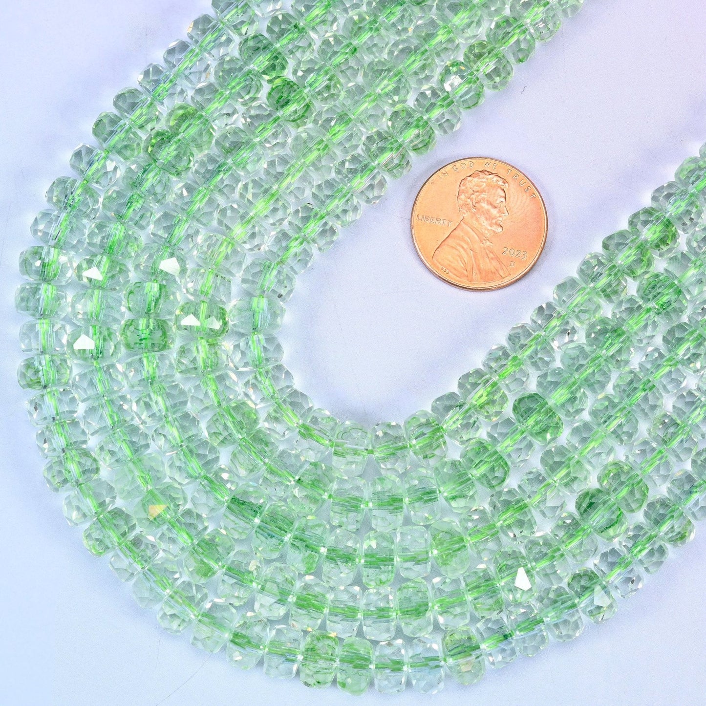 Faceted rondelle cut transparent green glass beads