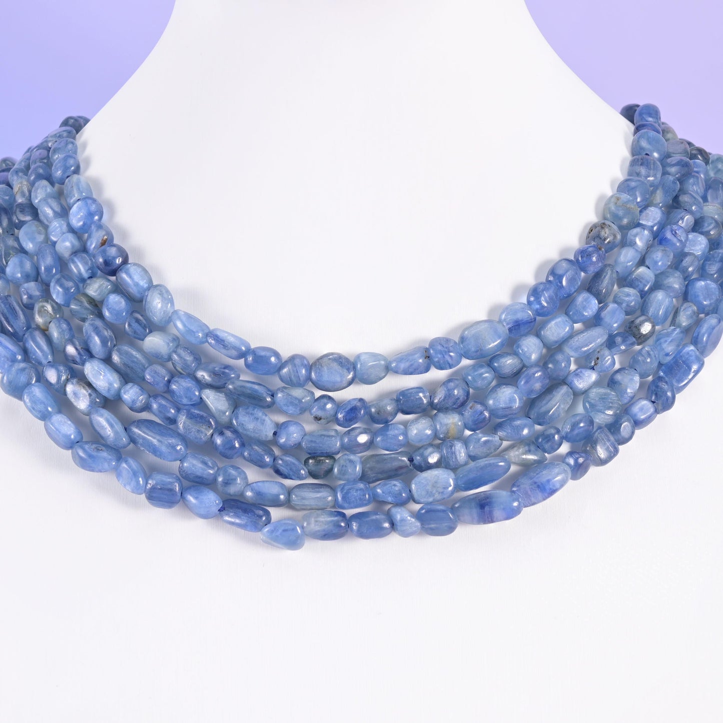 Multi-strand kyanite nugget necklace on a white display bust, soft blue pebbles at the collarbone