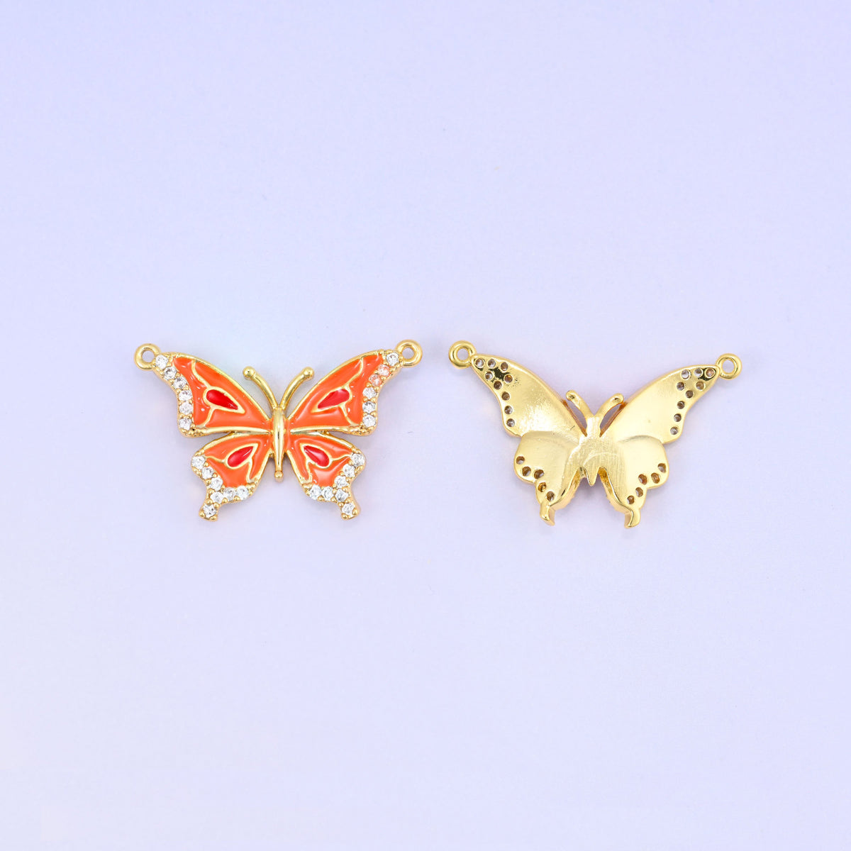 Orange enamel butterfly double connector pendant shown face up next to the plain gold back of a second piece, both with a loop at each upper wing tip.