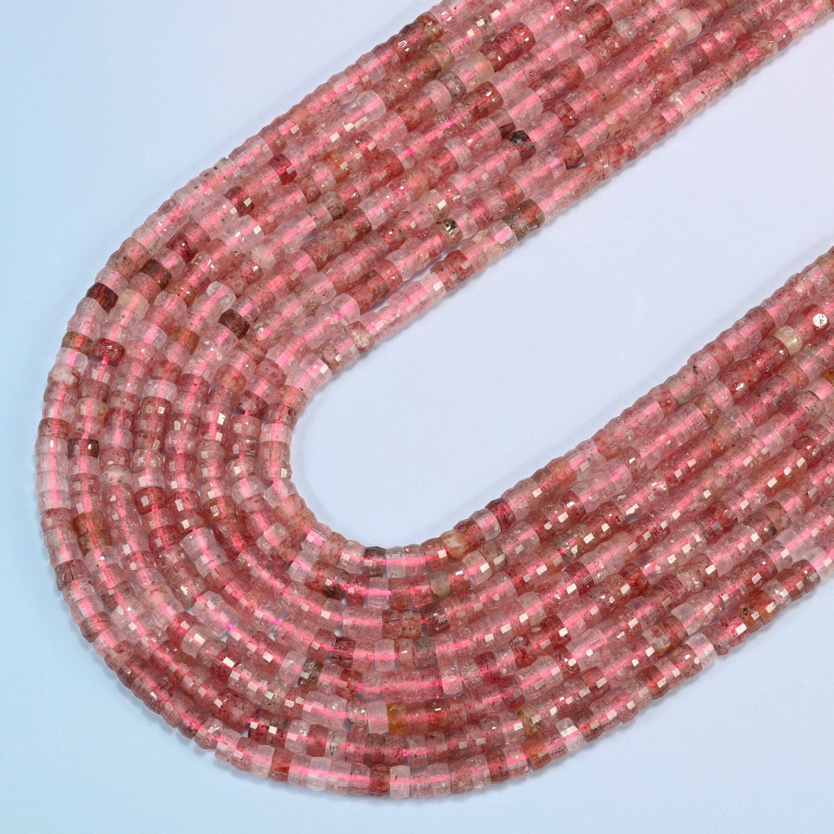 Strawberry quartz faceted heishi disc beads in several strands curved into a wide U, pink and clear stone with red flecks