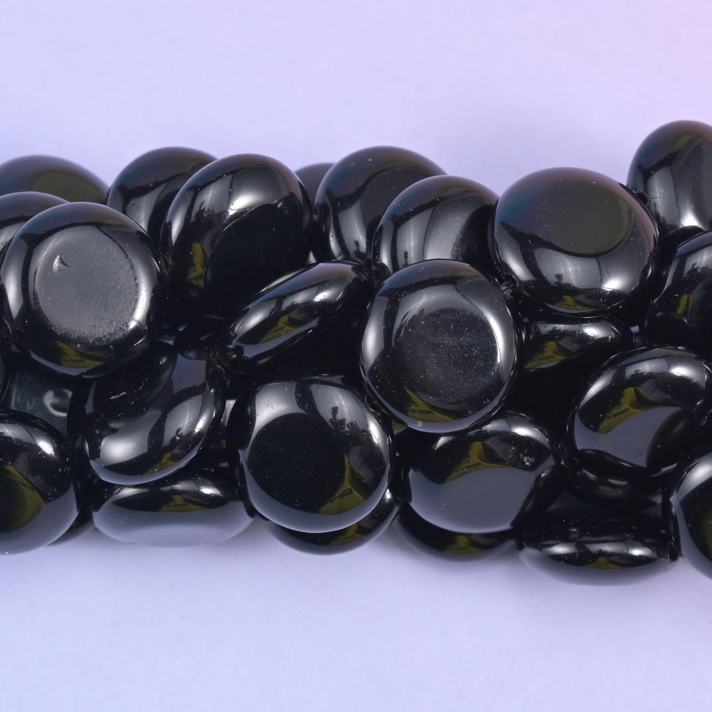 Macro crop of the polished coins where a green tint shows through the black at the thinner edges