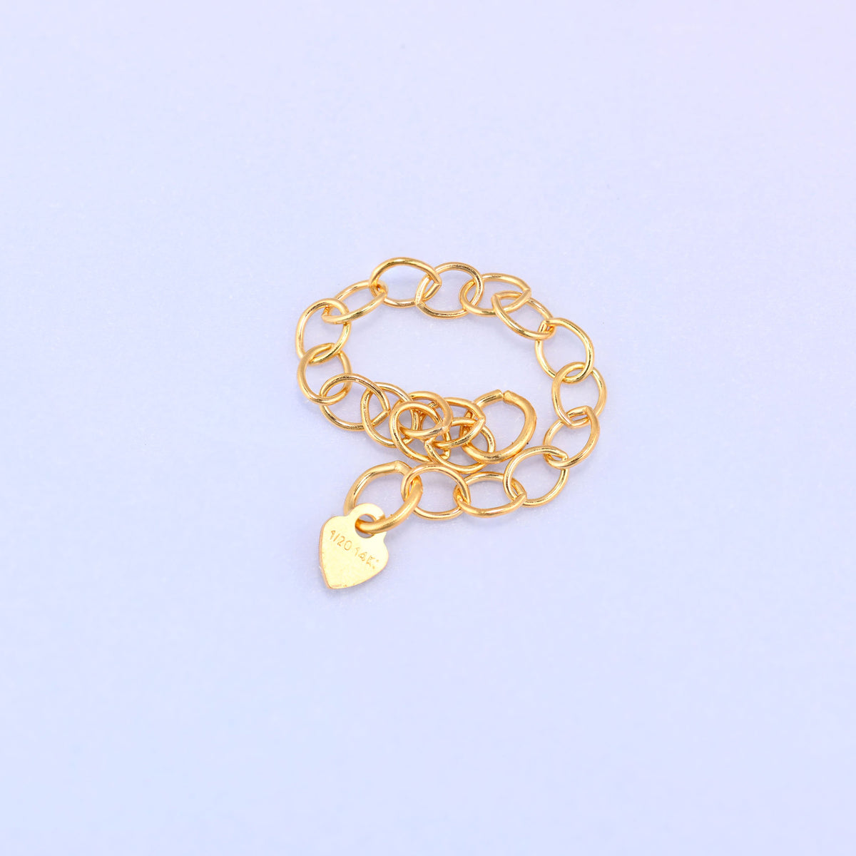 14K gold filled heart chain extender coiled into a loop, close-up showing the 1/20 14K stamp on the heart charm.