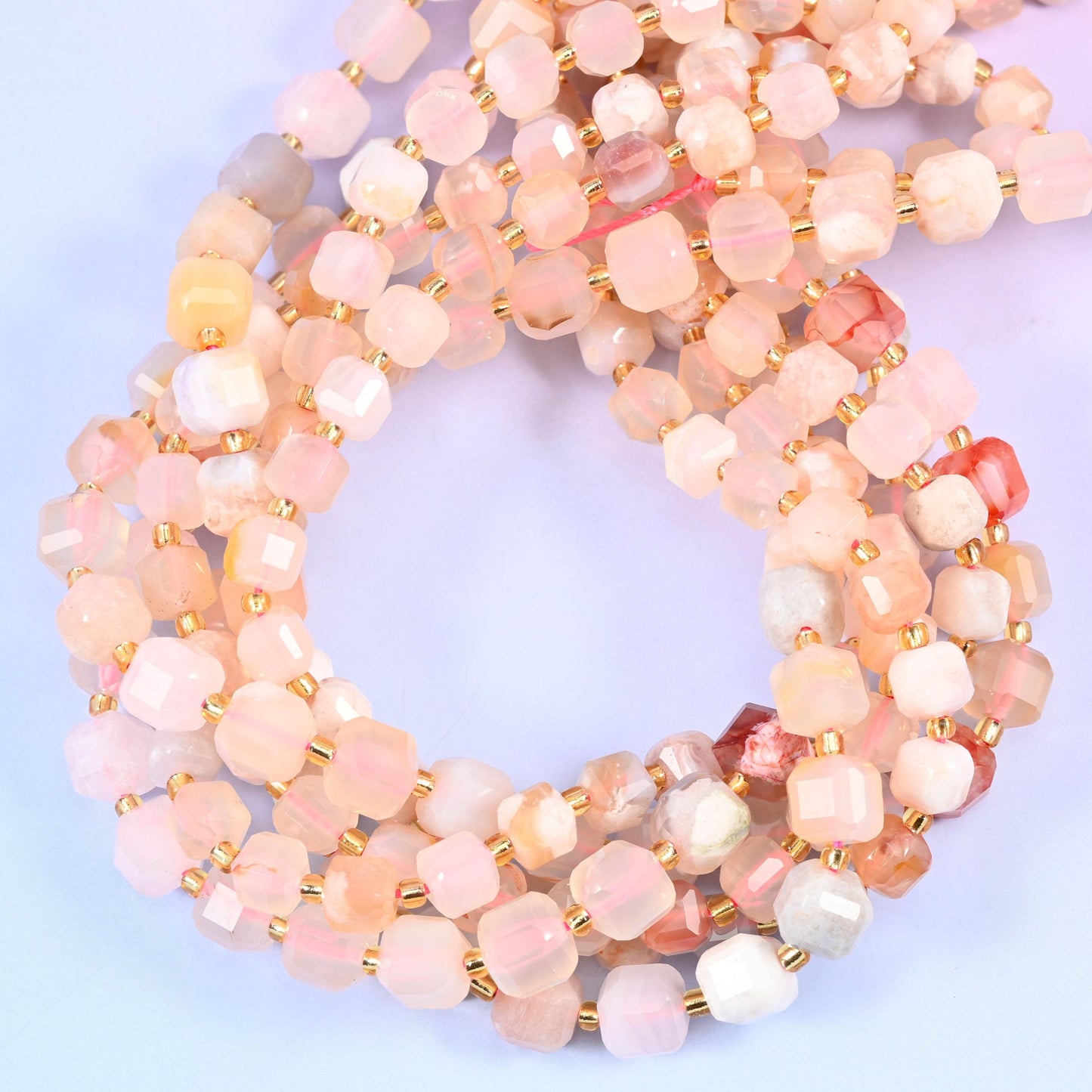A cherry-blossom palette of blush pink, cream, chalk white and pale apricot, some cubes clouded and others clear enough to glow, with the odd coral fleck breaking through.