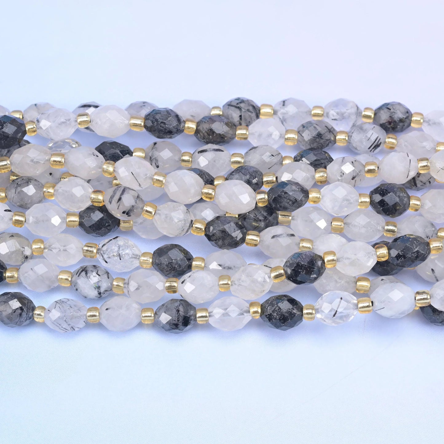 Faceted rice barrel cut black rutilated quartz beads