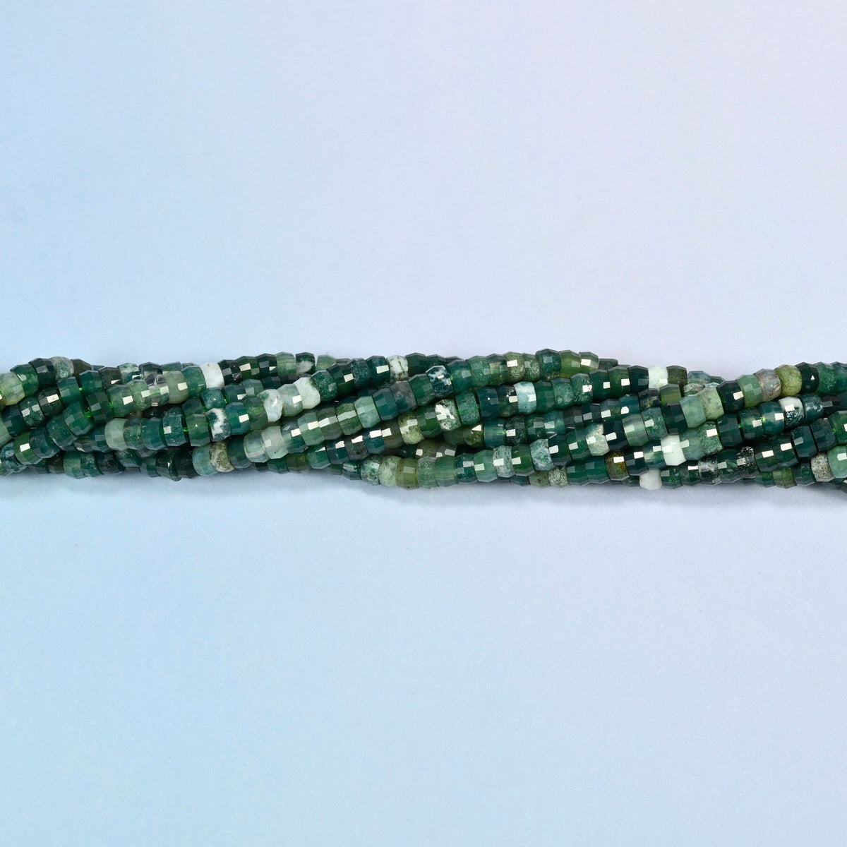 Strands of moss agate faceted heishi disc beads twisted together in a horizontal row