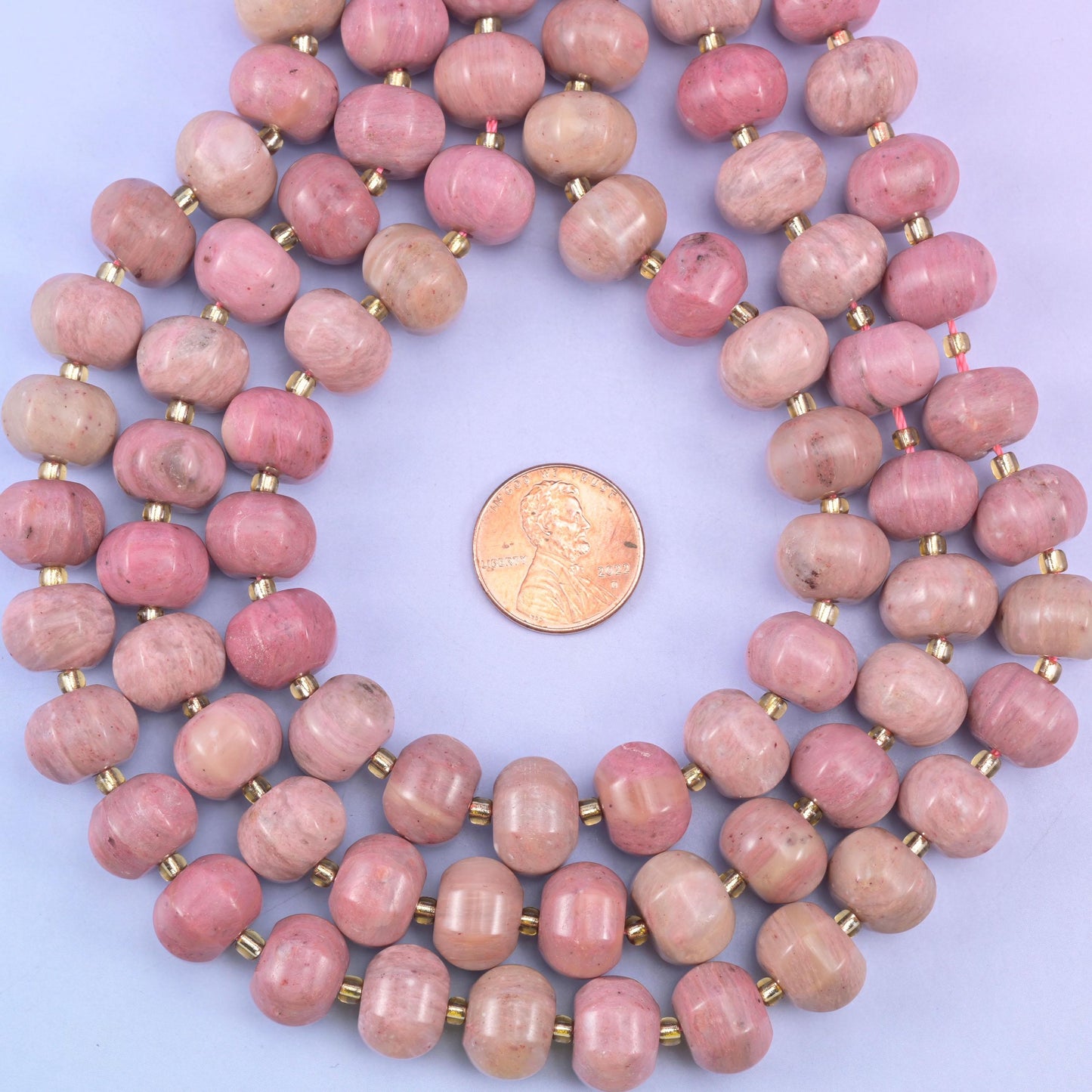 Pink rhodonite smooth pumpkin beads in warm mauve-pink with soft natural tonal shading