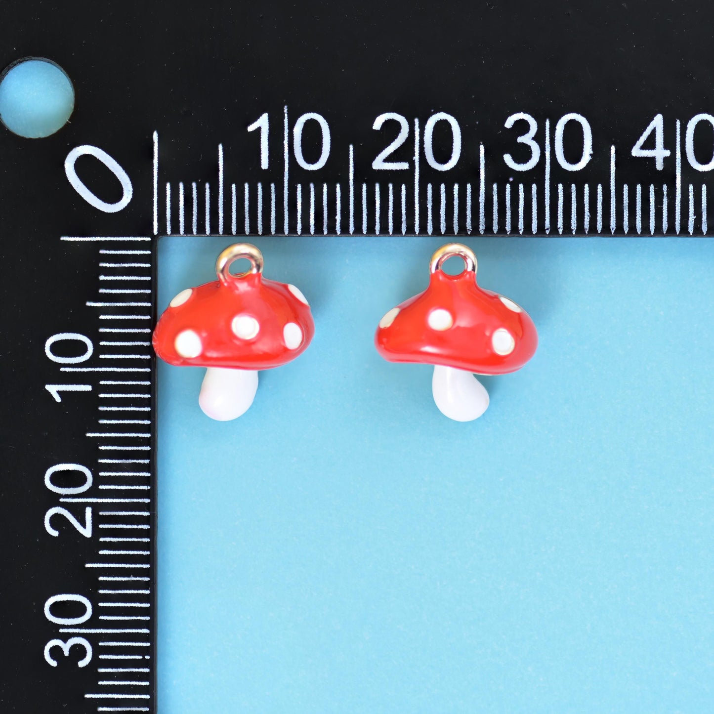 A chunky three-dimensional toadstool with a domed scarlet cap spotted in white and a short glossy white stem