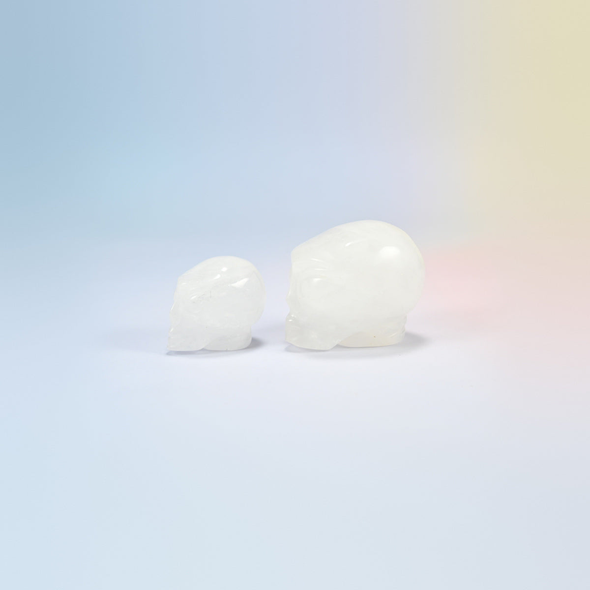 Two clear quartz alien head crystal carvings, 1.5 inch and 2 inch, milky clear natural stone