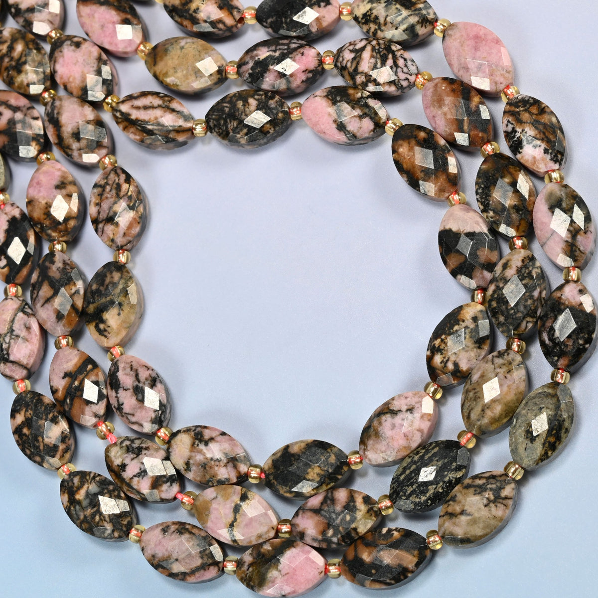 Rhodonite faceted flat oval beads curved into an open loop, dusty pink beads with black veins, some gray and tan