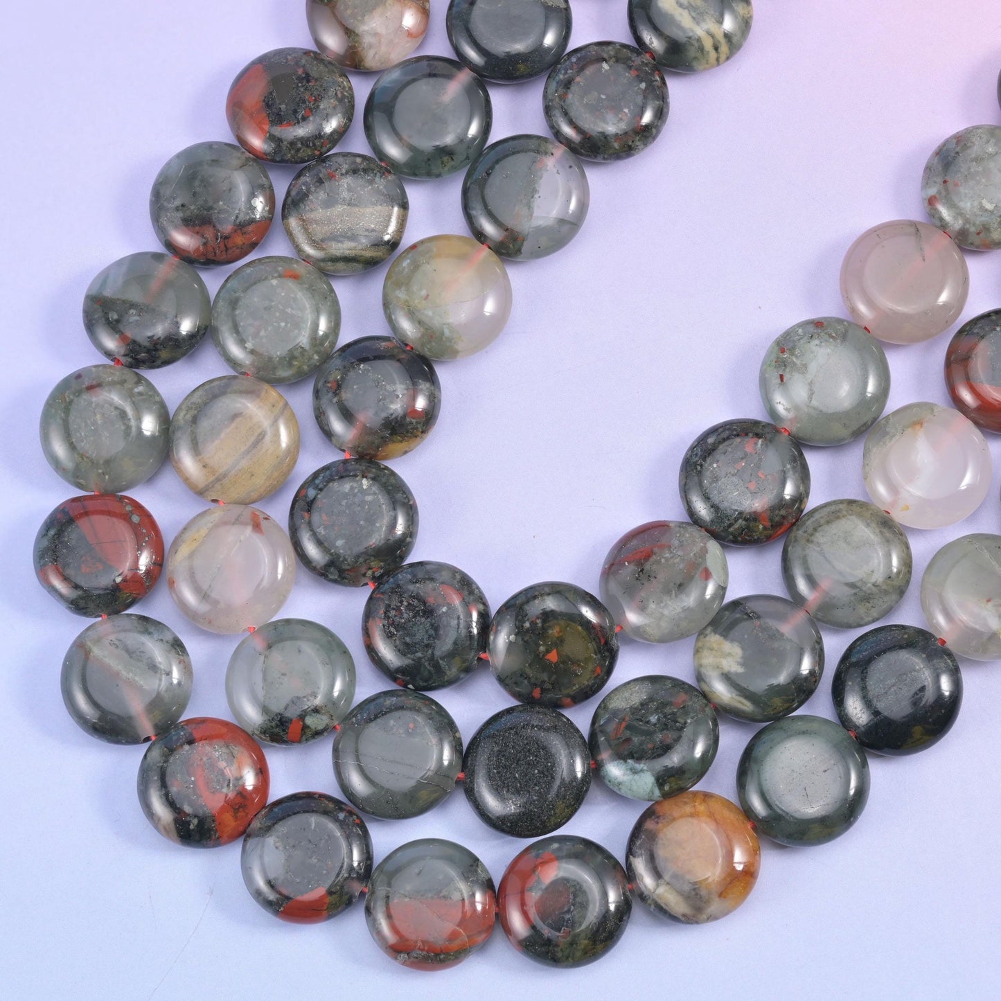 Coiled Bloodstone coin strands showing pale translucent quartz zones