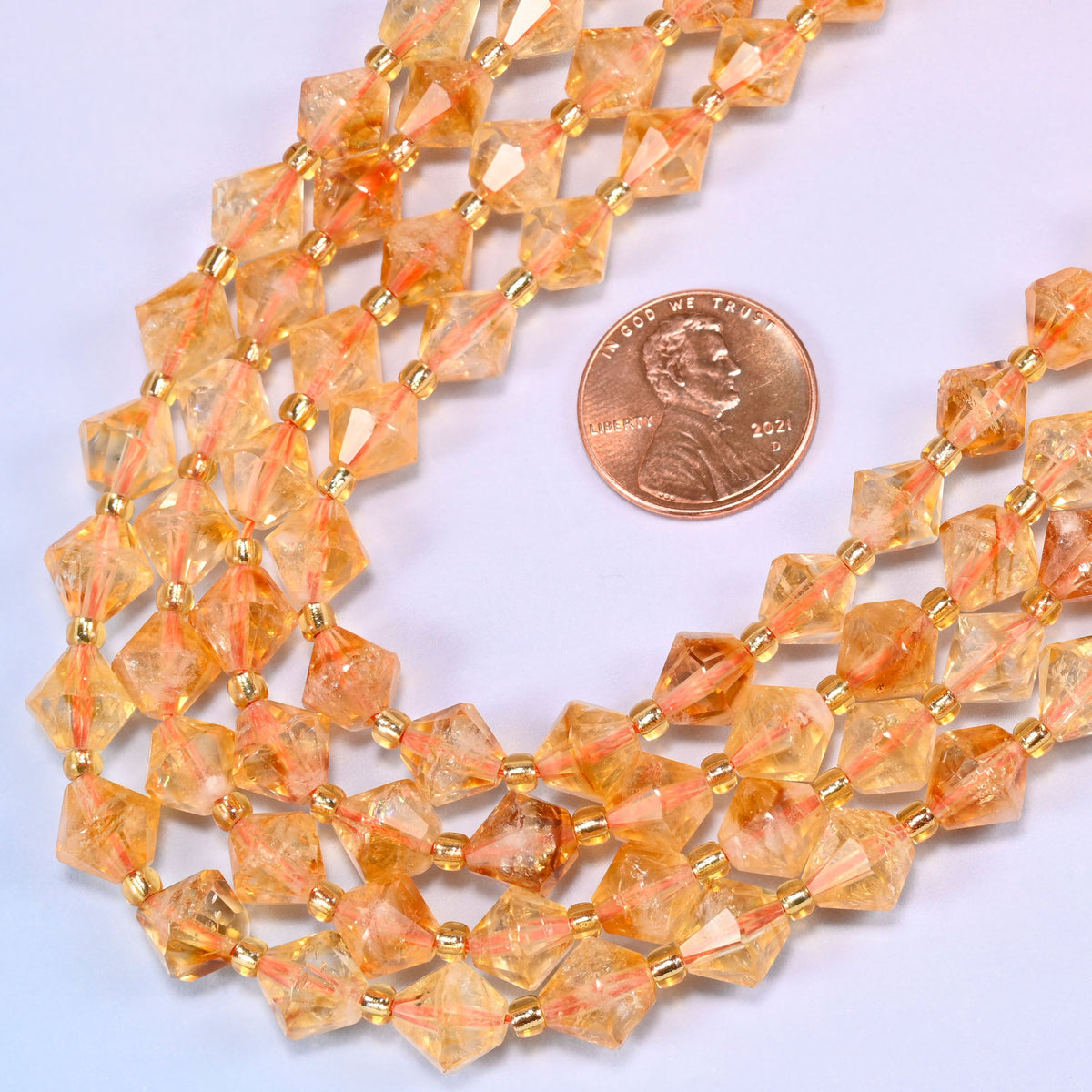 Citrine bicone beads in a wide curve, 8mm beads with a gold-tone spacer between each one.