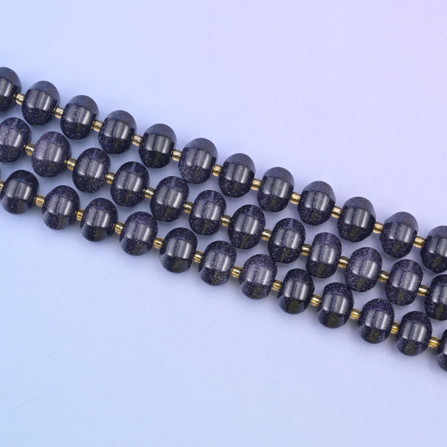 Diagonal run of 12x8mm Blue Sandstone pumpkin rondelles with small gold spacers