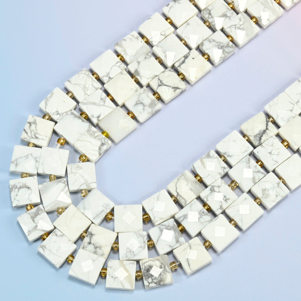 White howlite faceted flat square beads in several strands curved into a wide U, white stone with gray veining