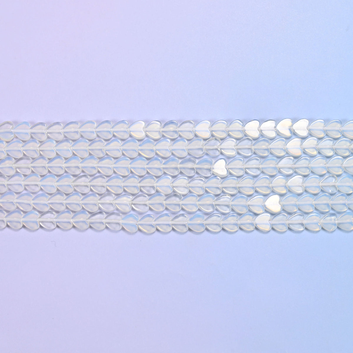 Opalite Flat Heart Beads in milky white with a blue opalescent glow