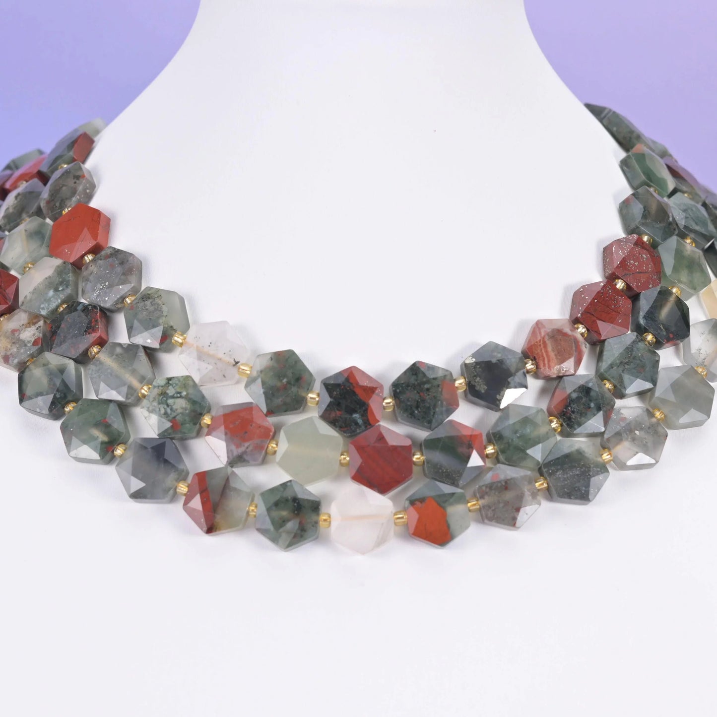 Sage green and rust red Bloodstone hexagons displayed on a white neck form