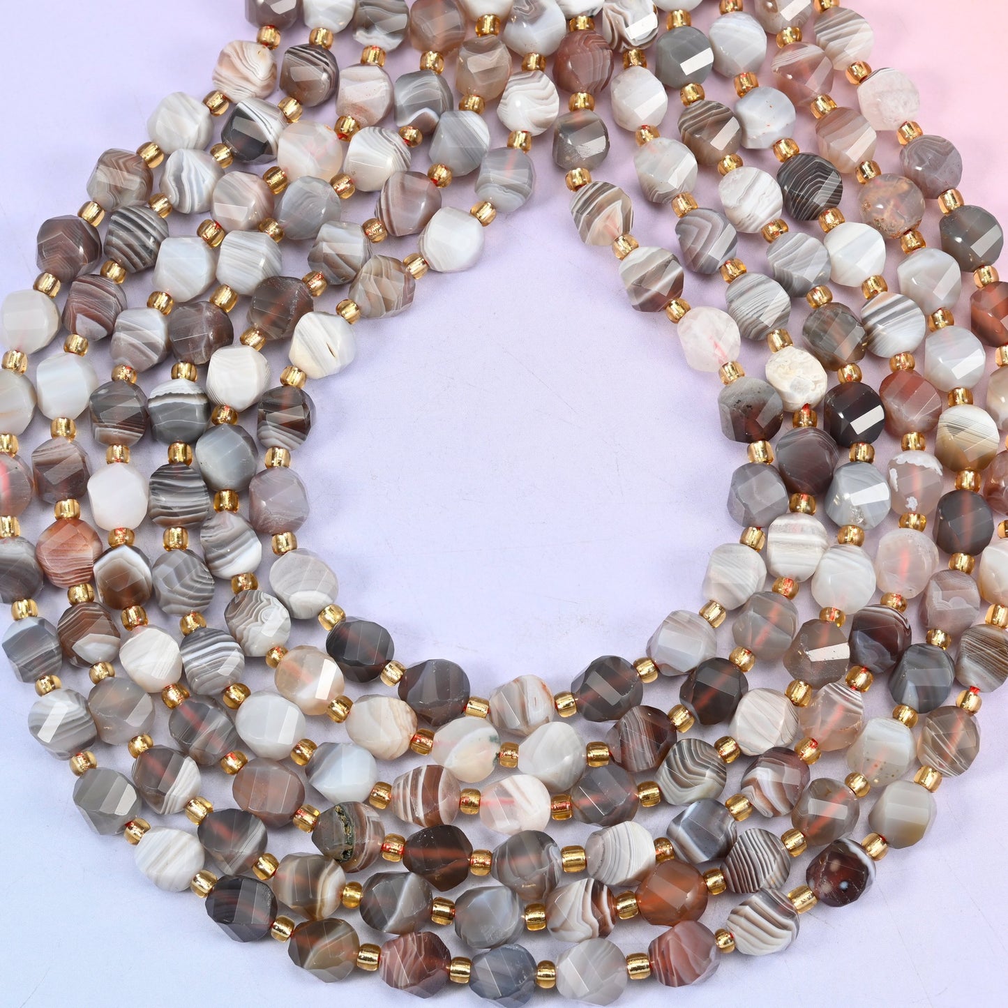 Botswana agate natural stone beads showing concentric eye rings on several beads within the banded pattern