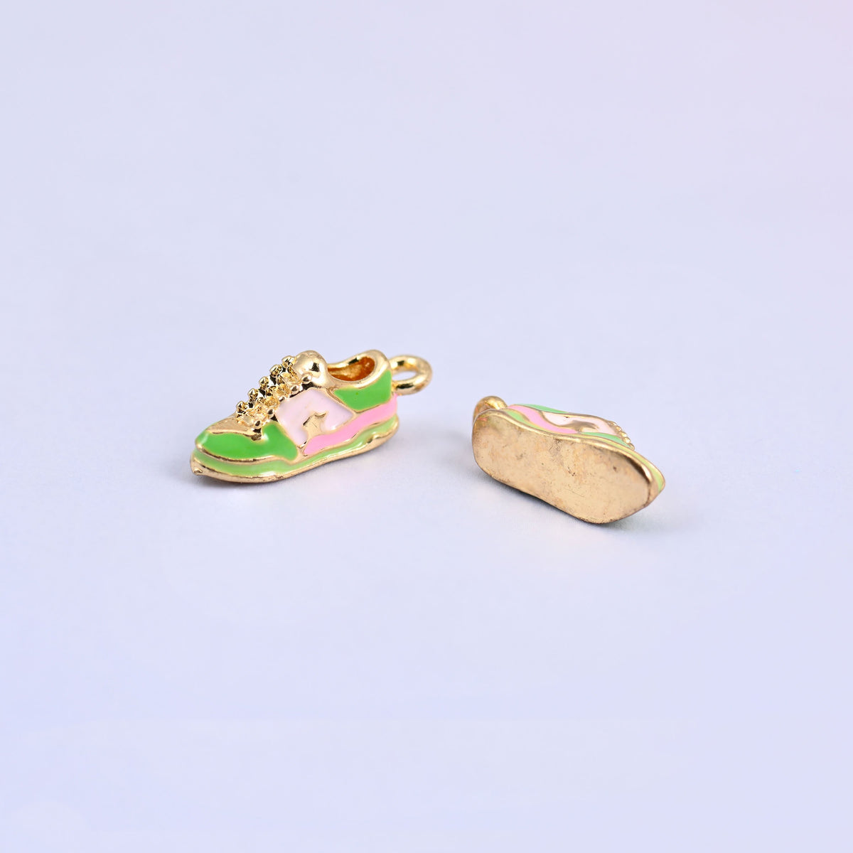 Green sneaker charm next to a second turned over to show the plain gold plated sole.