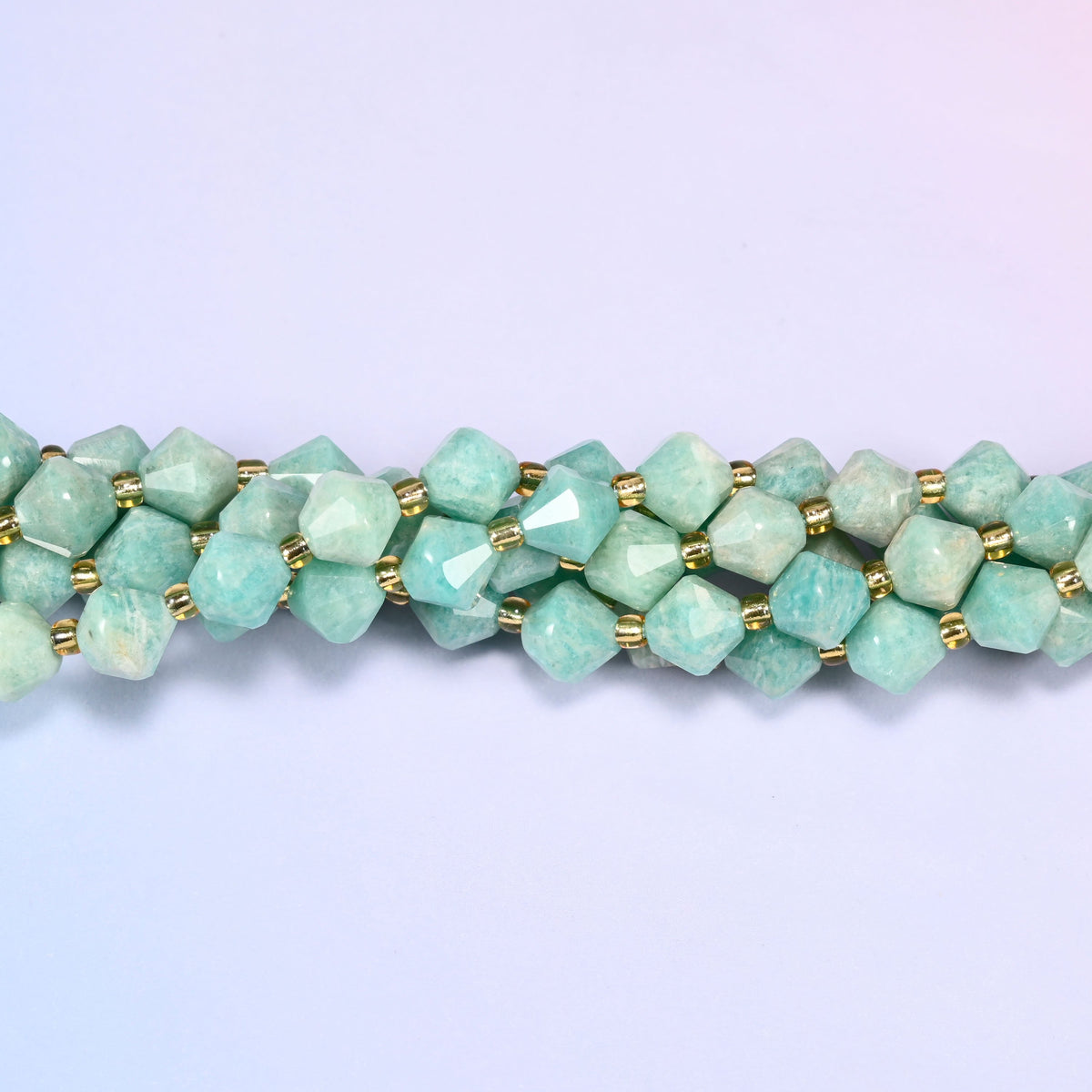 Green Amazonite faceted bicone beads 8mm with gold-tone spacers, close-up of the strand laid straight