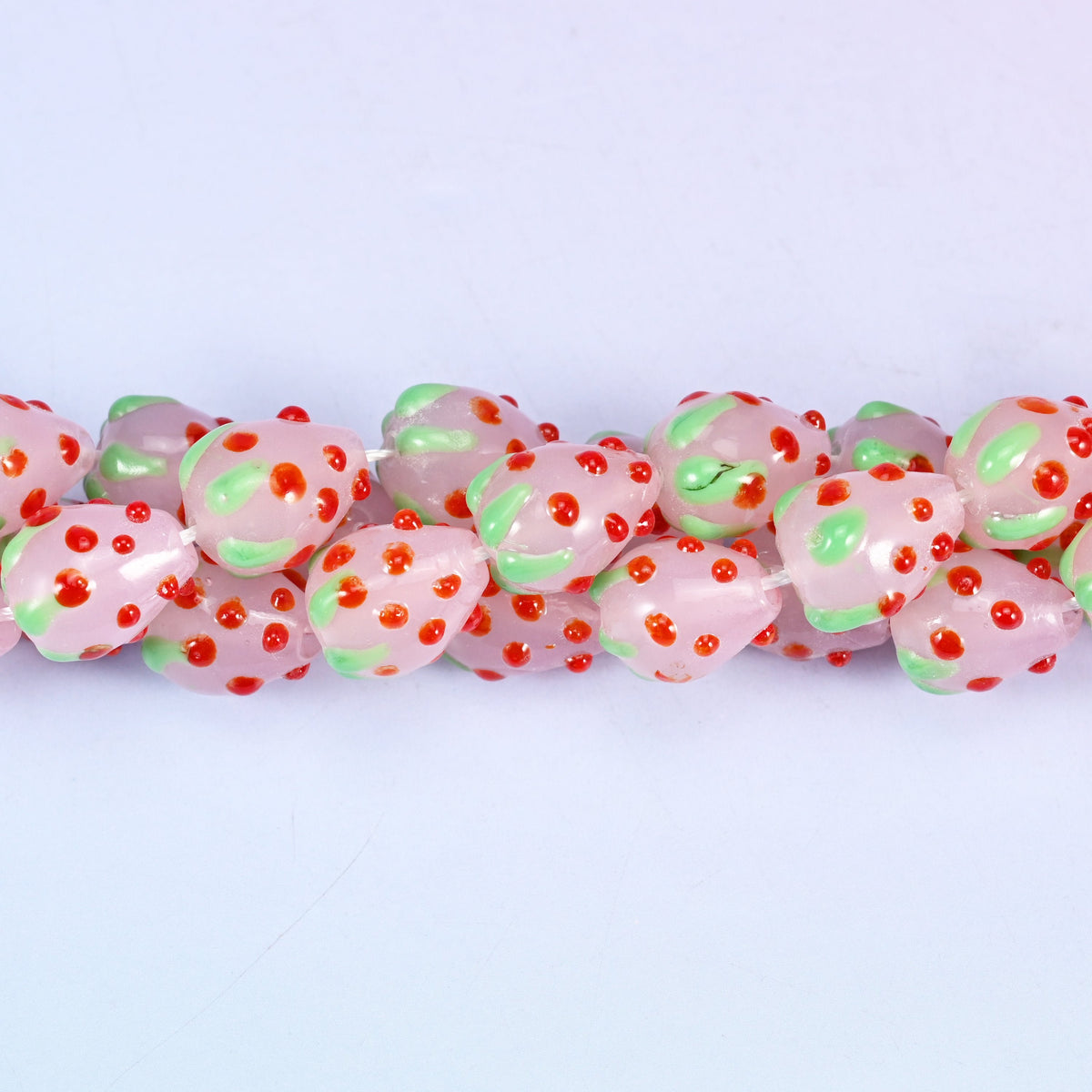 Man-made glass strawberry beads in pink, red and green