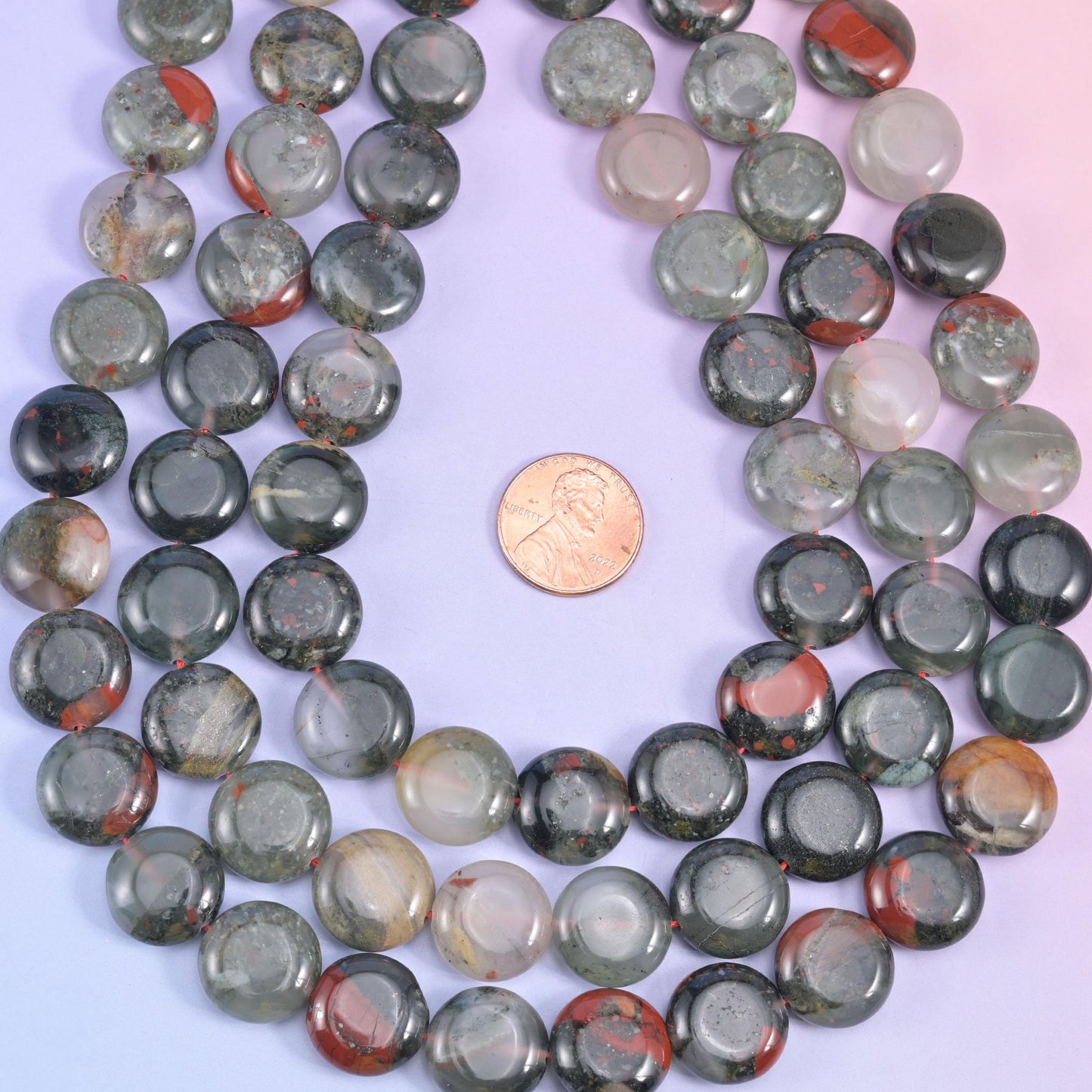 Looped African Bloodstone coins with a penny at the centre for scale