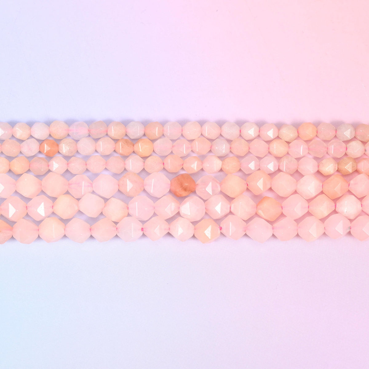 Pink Aventurine faceted beads in flat horizontal rows, blush pink with apricot patches, sold per 15.5 inch strand