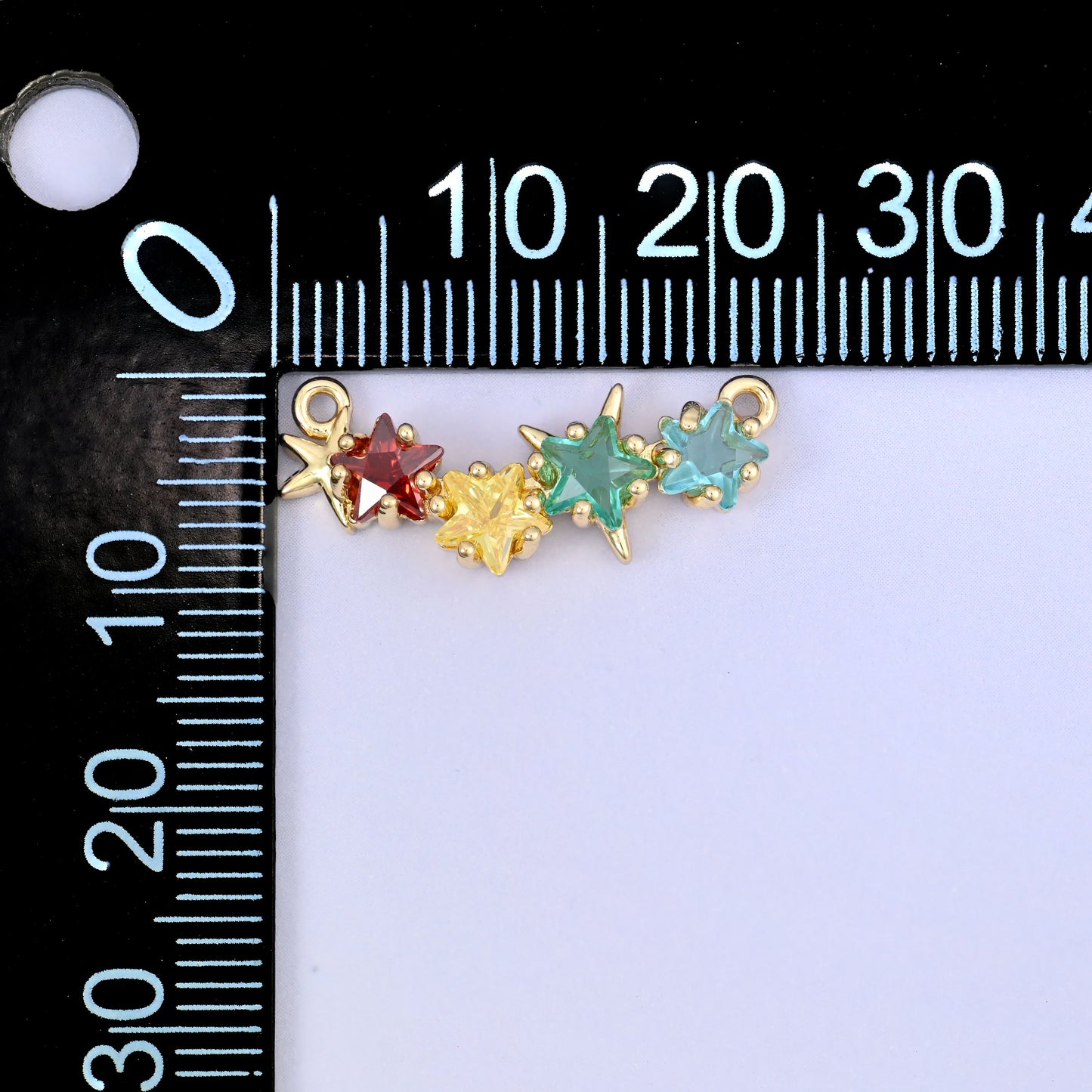 A multicolour four star zircon connector photographed beside a millimetre ruler for scale