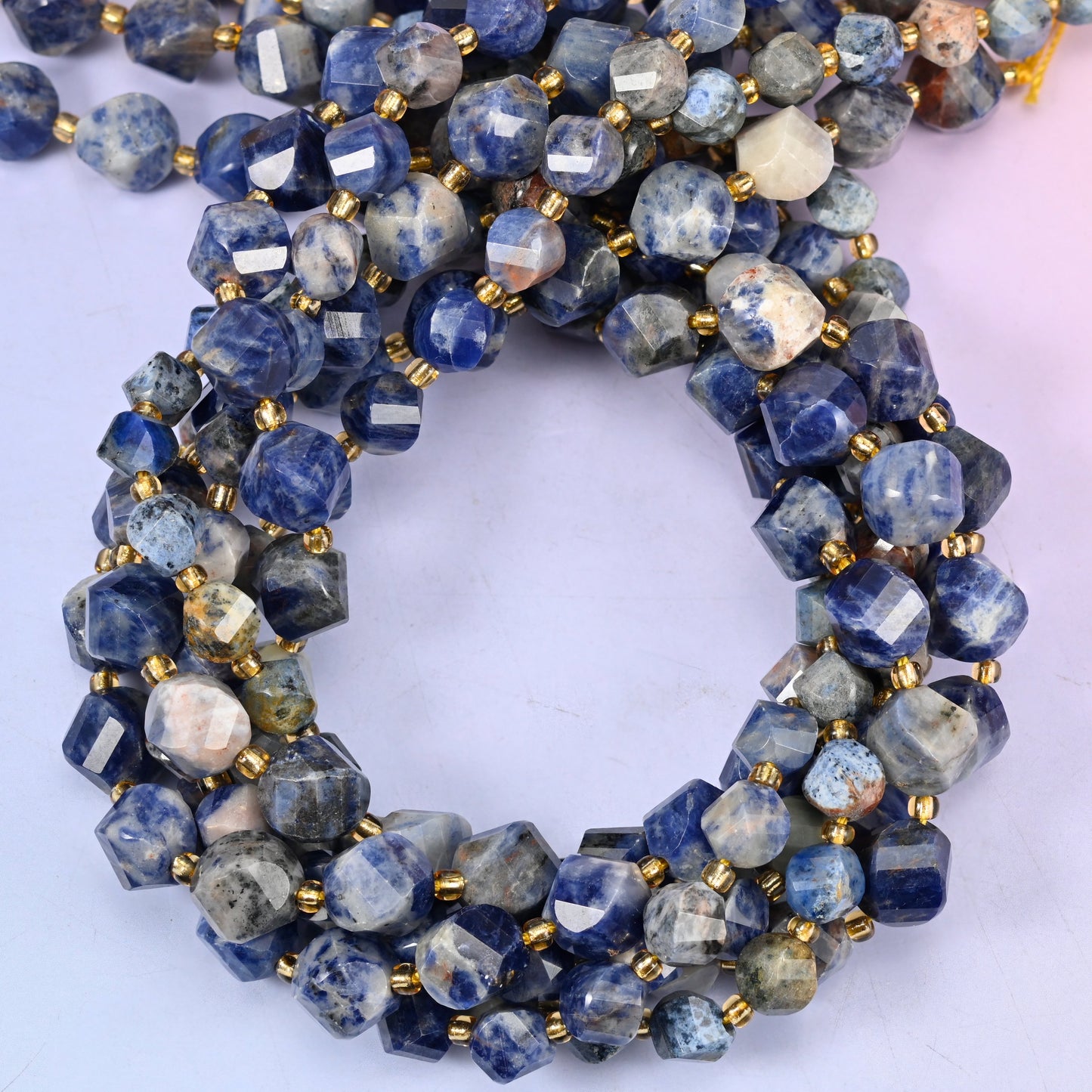 Orange Sodalite faceted spiral twist beads, close view of the coiled strands in deep blue mottled with white