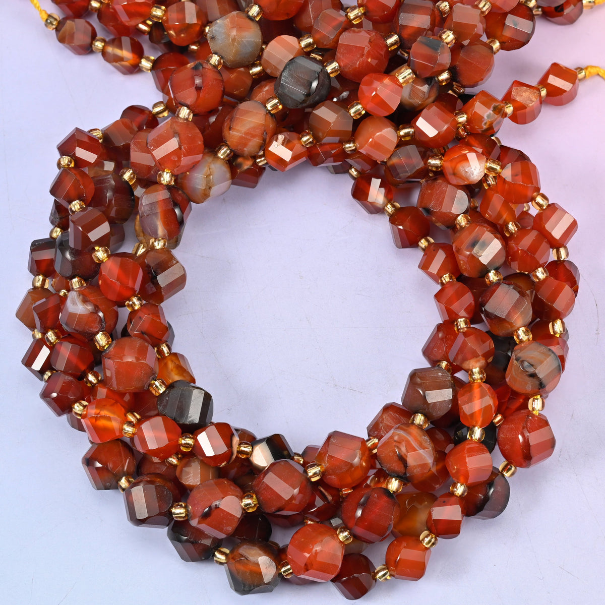 Red Agate faceted spiral twist beads, close view of the coiled strands showing deep red-brown with white and grey banding