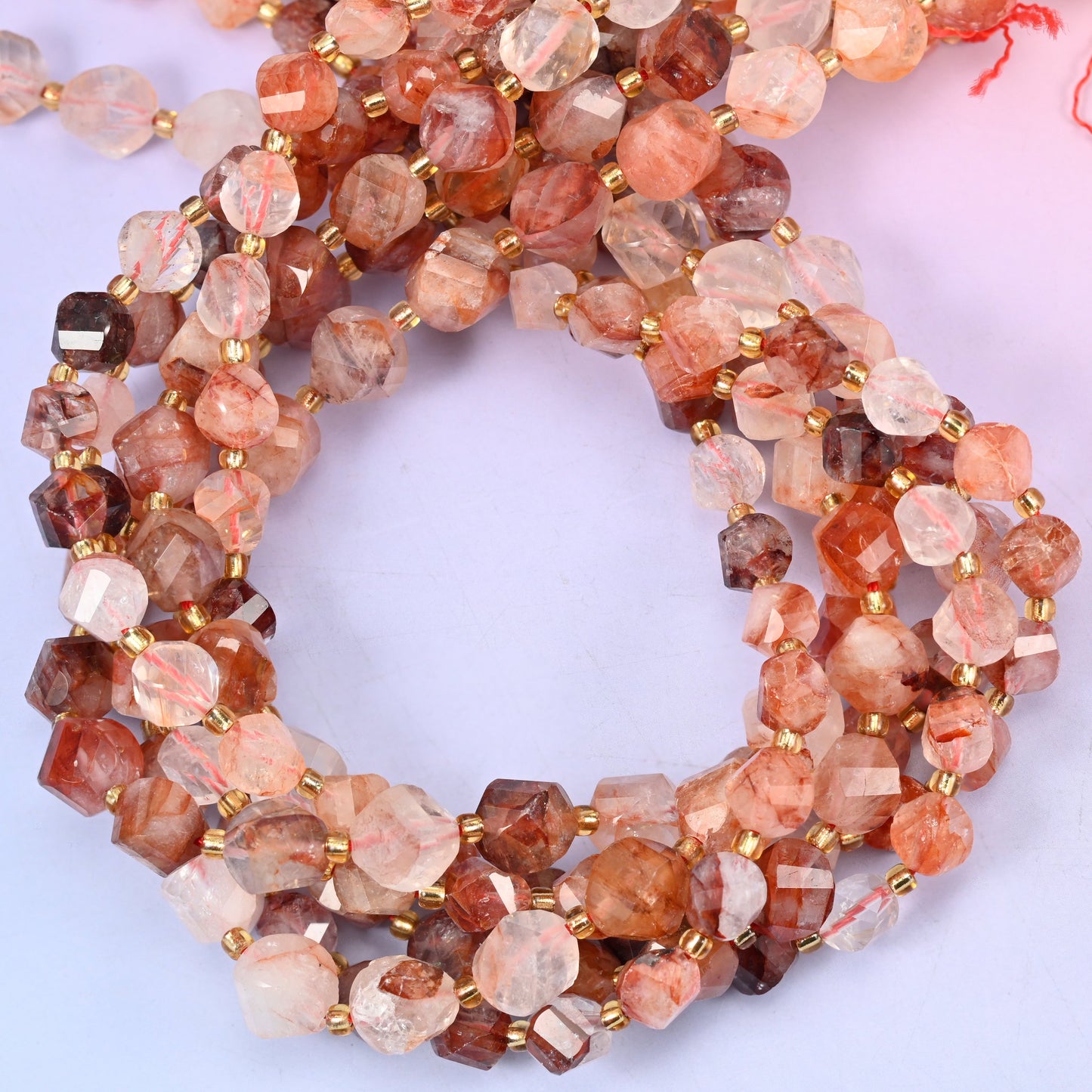 Red Hematoid Quartz faceted spiral twist beads, close view of the coiled strands showing translucent quartz clouded with rust red