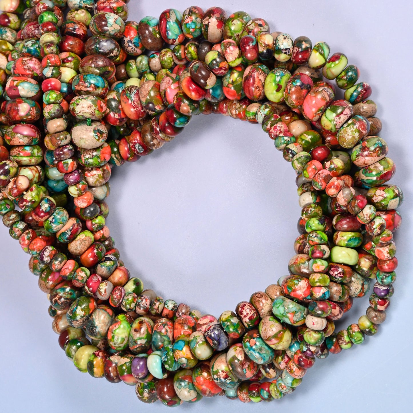 Dyed Sea Sediment Jasper rondelle beads, close view of the coiled strands mixing green, red and turquoise