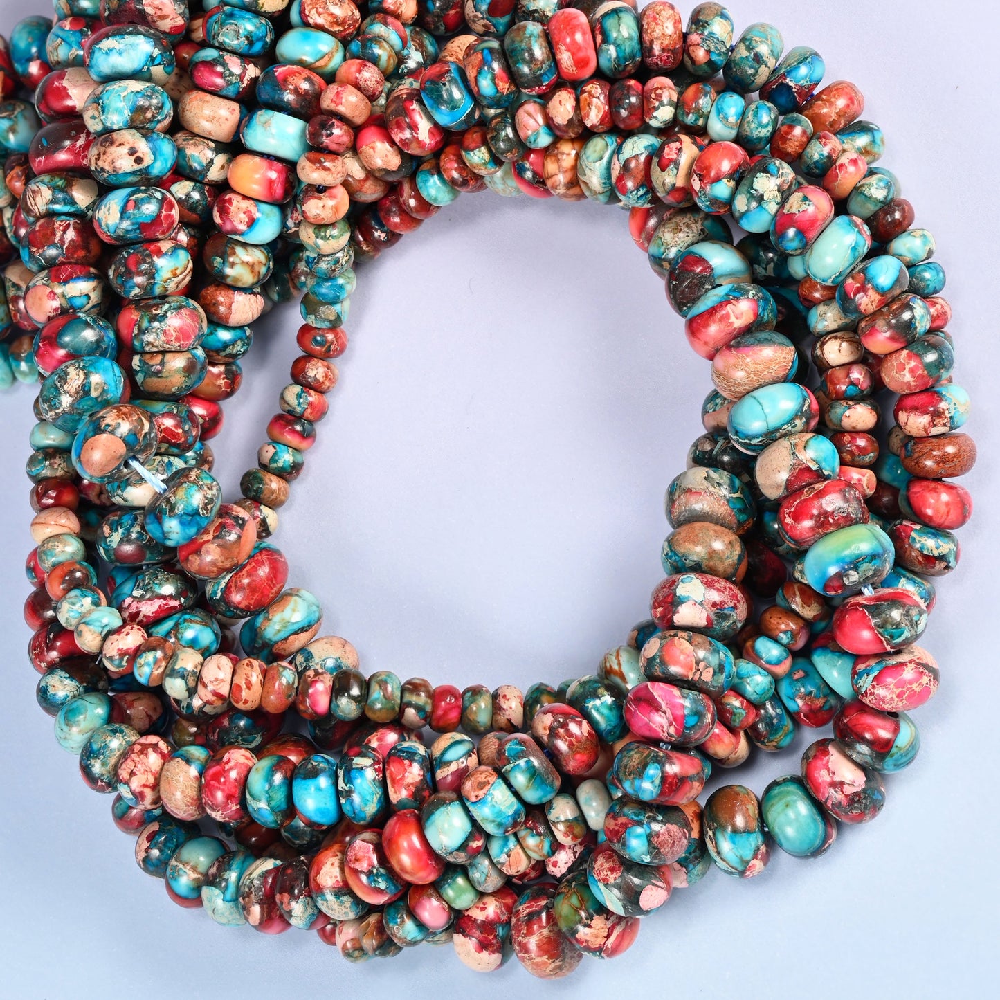 Dyed Sea Sediment Jasper rondelle beads, close view of the coiled strands mixing red, turquoise and tan