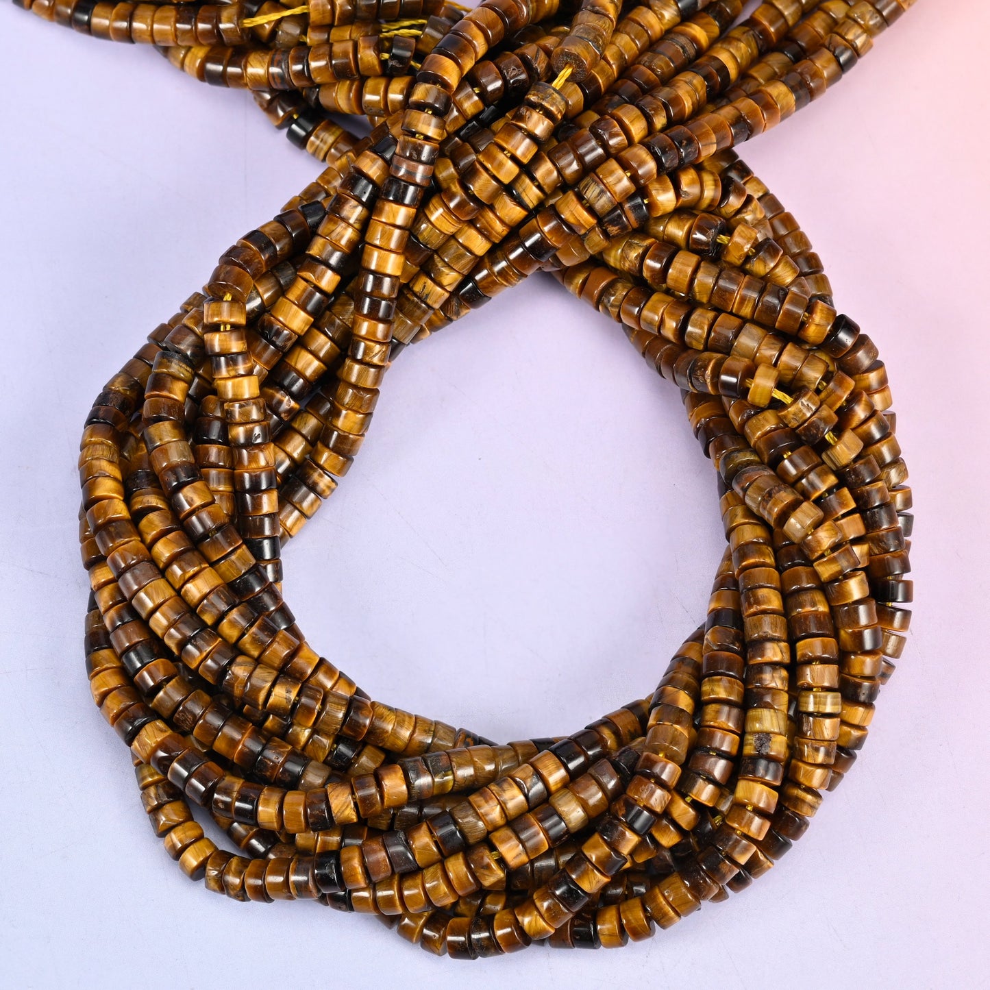 Tiger Eye smooth heishi disc beads, close view of the coiled strands showing golden brown bands with darker stripes
