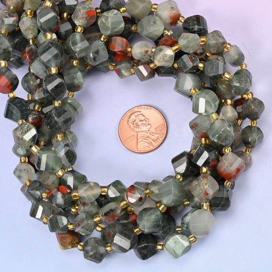 African Bloodstone faceted spiral twist bead strands coiled around a US penny for size reference