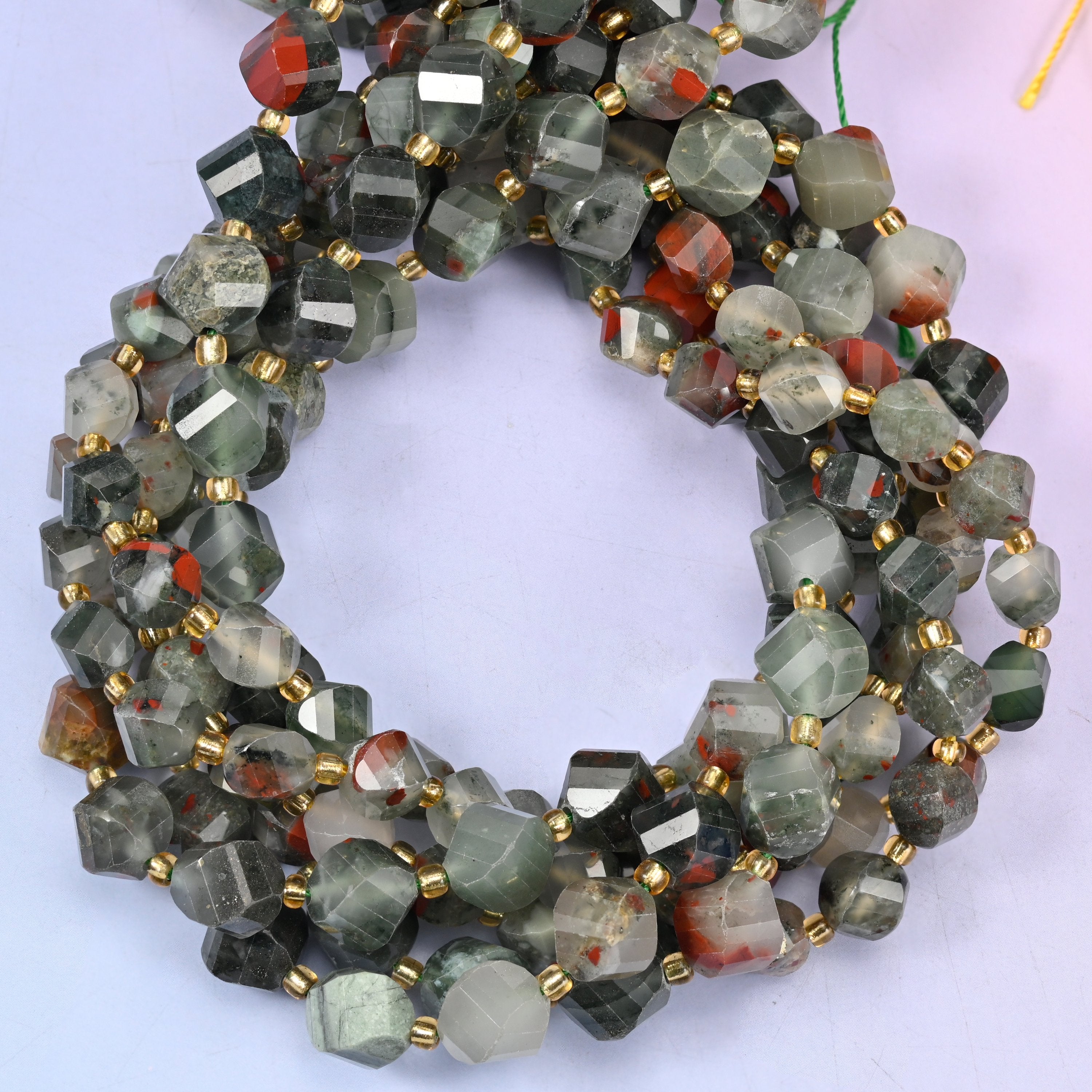 African Bloodstone faceted spiral twist beads, close view of the coiled strands showing mottled grey-green with rust red markings