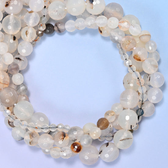 Black Flower Agate faceted round beads, close view of the coiled strands showing milky white with dark flecks